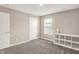 A carpeted bedroom with a storage cube, a window with blinds and white walls at 851 Sonoma Ln, Greenfield, IN 46140