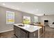 Open-concept kitchen with a center island, stainless steel appliances, and a view to the backyard and dining area at 851 Sonoma Ln, Greenfield, IN 46140