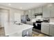 Well-lit kitchen with stainless steel appliances, light gray cabinets, island with sink, and a door to another room at 851 Sonoma Ln, Greenfield, IN 46140
