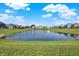 Still pond reflects a clear blue sky and white clouds in this neighborhood with well-manicured lawns at 851 Sonoma Ln, Greenfield, IN 46140
