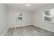 Light-filled bedroom with neutral walls, two windows, and modern gray wood-look flooring at 91 N Raceway Rd, Indianapolis, IN 46234