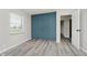 Bedroom featuring a built-in teal closet, neutral walls, and gray wood-look flooring at 91 N Raceway Rd, Indianapolis, IN 46234
