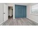 Cozy bedroom featuring a built-in teal closet and modern gray wood-look flooring at 91 N Raceway Rd, Indianapolis, IN 46234