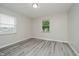 Minimalist bedroom with bright lighting, two windows, neutral walls, and gray wood-look flooring at 91 N Raceway Rd, Indianapolis, IN 46234