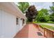 View of the house from the wood deck, surrounded by mature trees and grass at 91 N Raceway Rd, Indianapolis, IN 46234