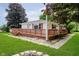 Back exterior view of a charming home with a wooden deck and well-manicured lawn at 91 N Raceway Rd, Indianapolis, IN 46234