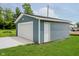 Garage with blue siding, a white door, and a well-maintained lawn at 91 N Raceway Rd, Indianapolis, IN 46234