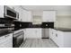 Beautiful kitchen highlighting stainless steel appliances, modern cabinetry, and sleek black countertops at 91 N Raceway Rd, Indianapolis, IN 46234