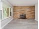 Inviting living room showcasing a stone fireplace and large window overlooking the green outdoors at 91 N Raceway Rd, Indianapolis, IN 46234