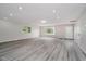 Bright living room with light gray walls, recessed lighting, and stylish gray wood-look flooring at 91 N Raceway Rd, Indianapolis, IN 46234