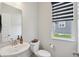 Clean and simple powder room with pedestal sink and modern fixtures, next to a window at 9671 Ridgecrest Ln, McCordsville, IN 46055
