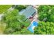 Aerial view of a home with a pool and a wooden deck, surrounded by trees at 1000 Leisure Ln, Greenwood, IN 46142