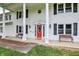Home exterior, up-close view of the home's entrance with bright red door and benches at 1000 Leisure Ln, Greenwood, IN 46142