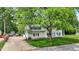 Traditional two-story home with a well-manicured lawn, mature trees, and a spacious driveway at 1000 Leisure Ln, Greenwood, IN 46142