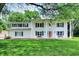 Charming two-story home with a large front yard, white siding and a bright red front door at 1000 Leisure Ln, Greenwood, IN 46142