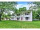 Two-story colonial with red front door, black shutters, benches, white siding and beautiful front lawn at 1000 Leisure Ln, Greenwood, IN 46142