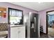 This kitchen features a stainless steel refrigerator, white cabinetry, and a window with natural light at 1000 Leisure Ln, Greenwood, IN 46142