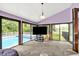 Living room with vaulted ceiling, carpet flooring, and access to pool and backyard through sliding glass doors at 1000 Leisure Ln, Greenwood, IN 46142