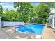 Backyard in-ground pool surrounded by a white fence and mature trees offering a private oasis at 1000 Leisure Ln, Greenwood, IN 46142