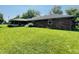 Spacious backyard with a well-maintained lawn, a brick house, and mature trees at 1008 Whispering Trl, Greenfield, IN 46140