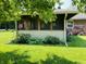 View of the screened-in porch surrounded by lush landscaping and greenery at 1008 Whispering Trl, Greenfield, IN 46140