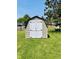 A backyard storage shed with double white doors provides extra storage at 1008 Whispering Trl, Greenfield, IN 46140
