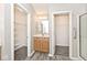 Primary bathroom featuring double sinks, a lighted mirror, and a walk-in closet at 10668 Whippoorwill Ln, Indianapolis, IN 46231