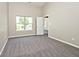 Bright bedroom featuring plush gray carpet, neutral paint, and a large window at 10668 Whippoorwill Ln, Indianapolis, IN 46231