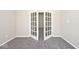 Bedroom featuring neutral paint, plush gray carpet, and paneled french doors at 10668 Whippoorwill Ln, Indianapolis, IN 46231