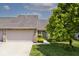 Exterior of a home with attached garage, driveway, lush lawn, and landscaping at 10668 Whippoorwill Ln, Indianapolis, IN 46231