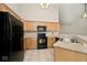Bright kitchen with wood cabinetry and black appliances at 10668 Whippoorwill Ln, Indianapolis, IN 46231