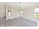 Bright living room featuring vaulted ceiling, plush carpet, and ample natural light from multiple windows at 10668 Whippoorwill Ln, Indianapolis, IN 46231