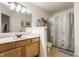 Bathroom showcasing a wooden vanity with countertop sink and modern shower with curtain at 1112 Halifax Ct, Indianapolis, IN 46231