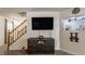 Comfortable living room with a large TV, wooden staircase, and views into the kitchen at 1112 Halifax Ct, Indianapolis, IN 46231