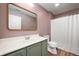 Well-lit bathroom featuring a vanity with green cabinets, a wooden framed mirror and a shower with a white curtain at 11138 Bear Hollow Dr, Indianapolis, IN 46229