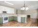 Kitchen with green and white cabinets, modern appliances and an open view to the living room at 11138 Bear Hollow Dr, Indianapolis, IN 46229