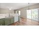 Kitchen leading to outdoor seating through a glass door, featuring modern appliances and green cabinets at 11138 Bear Hollow Dr, Indianapolis, IN 46229