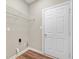 Bright laundry room with a metal shelf, white door, and wood-look flooring at 11138 Bear Hollow Dr, Indianapolis, IN 46229