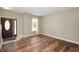 Bright room with hardwood floors and an oval window door, with a large sunlit window nearby at 11138 Bear Hollow Dr, Indianapolis, IN 46229