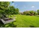 Spacious backyard with lush green lawn, mature trees, and decorative planters at 11354 Royal Pl, Carmel, IN 46032