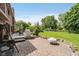 Paver patio with outdoor kitchen area and a large yard with mature trees and landscaping at 11354 Royal Pl, Carmel, IN 46032