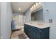 Well-lit bathroom featuring a double sink vanity and a shower/tub combo with sliding glass doors at 11354 Royal Pl, Carmel, IN 46032