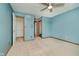 Spacious bedroom featuring neutral carpet, ceiling fan, walk-in closet and a lovely blue paint at 11354 Royal Pl, Carmel, IN 46032