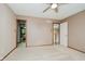 Bedroom featuring neutral carpeting, ceiling fan, and three doorways to closet, bathroom, and hall at 11354 Royal Pl, Carmel, IN 46032