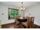 Cozy dining room with hardwood table, chairs, and large windows offering natural light and views of the backyard at 11354 Royal Pl, Carmel, IN 46032