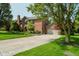 Stately brick home featuring mature trees, manicured landscaping, and spacious driveway at 11354 Royal Pl, Carmel, IN 46032