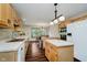 Open kitchen featuring stainless appliances, laminate countertops, wood cabinets, island, and access to dining room at 11354 Royal Pl, Carmel, IN 46032