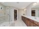 Bathroom featuring tile floors, dual sinks, a tiled walk-in shower with glass door, and a view into the walk-in closet at 11840 Crossbill Ct, Noblesville, IN 46060