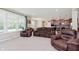 Spacious living room featuring plush seating, carpet floors, large windows, and an open layout to kitchen at 11840 Crossbill Ct, Noblesville, IN 46060