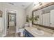 Stylish bathroom with a modern vanity, decorative mirror, and access to a walk-in closet at 12259 Sweet Creek Trl, Fishers, IN 46037